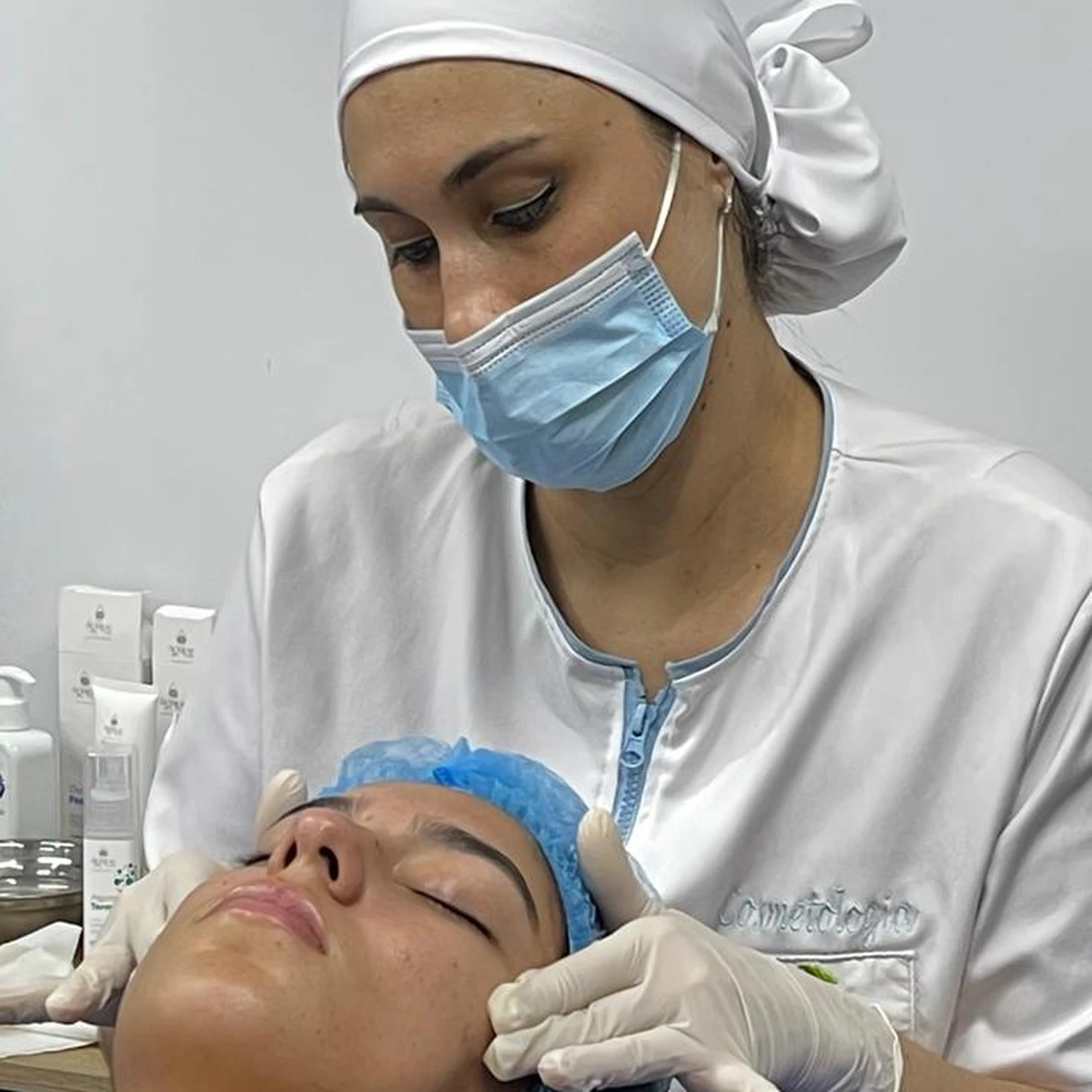 Estudiantes practicando técnicas de estética facial y corporal en aula de formación de Colegiatura